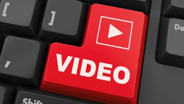 Rote Tastaturtaste mit der Aufschrift „VIDEO“ und Play-Symbol auf einer Computer-Tastatur. Das Bild steht für Video-Lerninhalte, digitale Schulungen und multimediales Lernen im Online-Bereich.