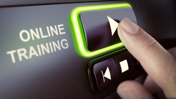 Nahaufnahme eines Fingers, der auf einen leuchtenden Startknopf mit der Aufschrift „Online Training“ drückt. Das Bild symbolisiert digitales Lernen, E-Learning und den einfachen Zugang zu Online-Schulungen und Weiterbildungen.